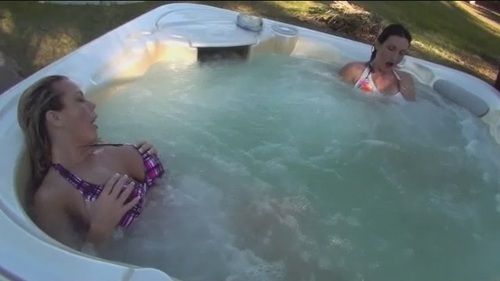 Brunette masturbates in hot tub