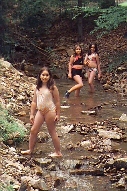 girls wading in pond