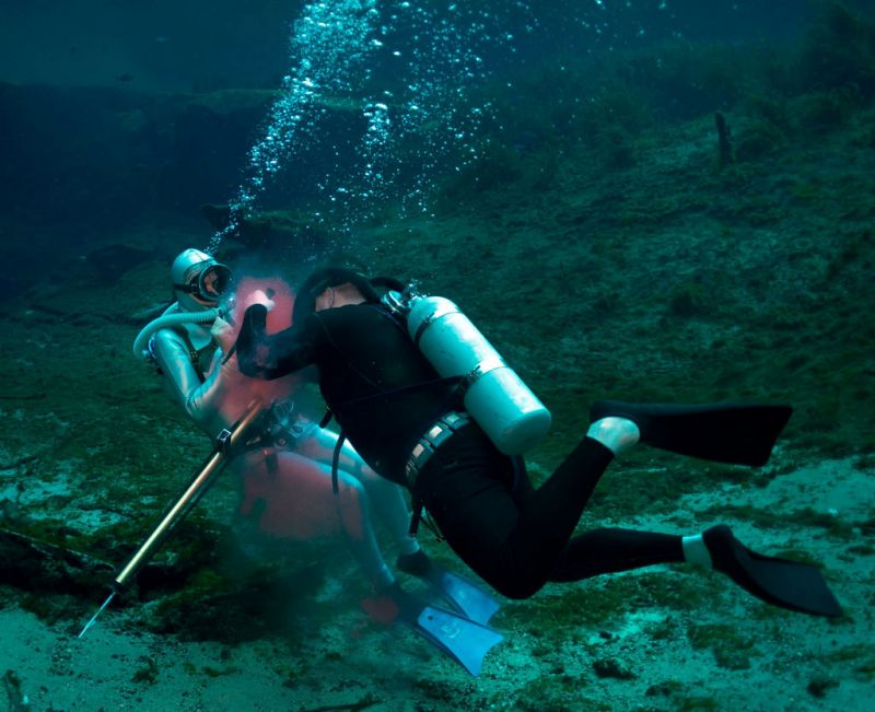 scuba divers underwater fighting women